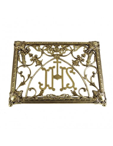 Atril de sobremesa de bronce con simbolo de JHS en el centro y detalles florales labrados.
Medida: 30 cm de alto x 41 cm de an