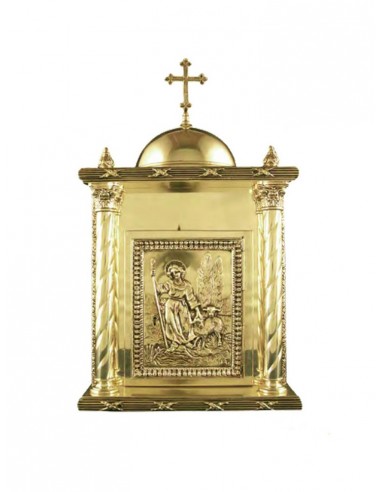 Sagrario de bronce con la imagen del buen pastor labrada y columnas.
La parte superior concluye con una cúpula y una cruz.

