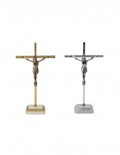 Crucifijo de sobremesa con peana cuadrada en blanco y dorado.
 La cruz es fina. 
En la parte superior de la cruz se encuentra