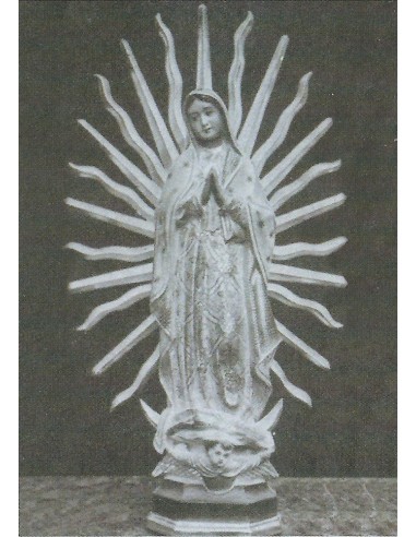 Imagen en madera de la Virgen de Guadalupe.
La figura muestra a nuestra señora de pie rezando sobre un pedestal sujeto por áng