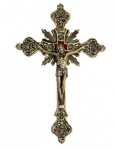 Crucifijo de pared con cristo en metal.
Los extremos de la cruz tienen forma redondeada, detrás salen unos rayos de luz y el f